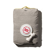 beige colour dog bed with toys on it